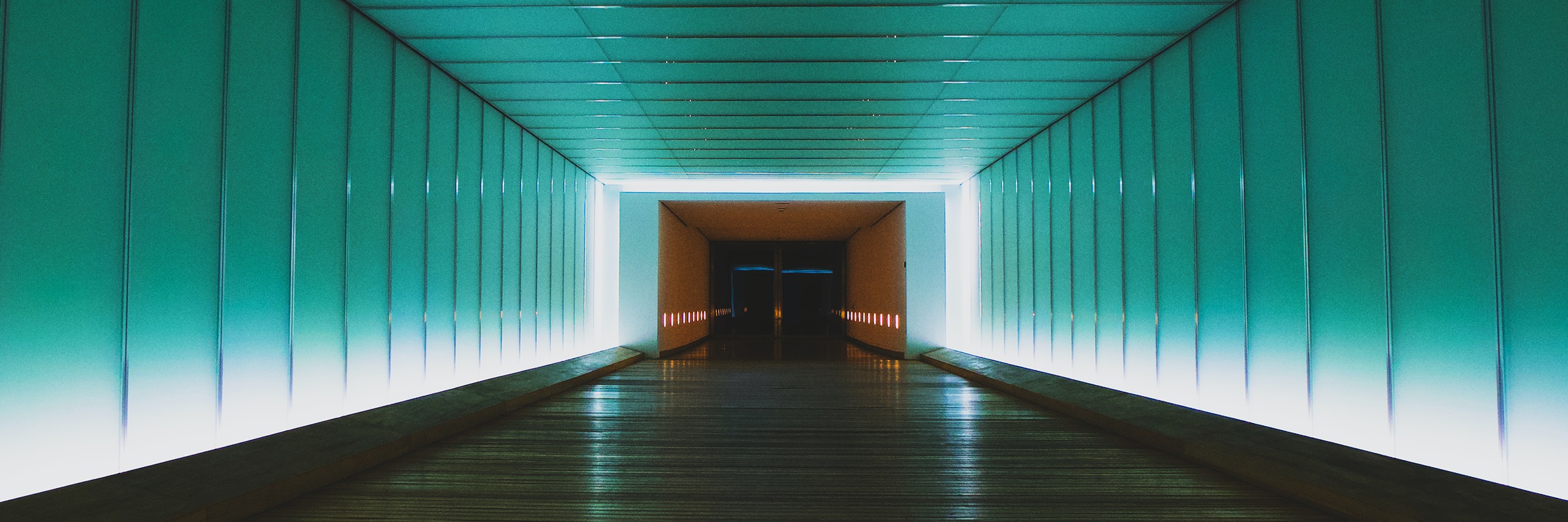 Ein langer Gang, der vorne beleuchtet und hinten dunkel ist