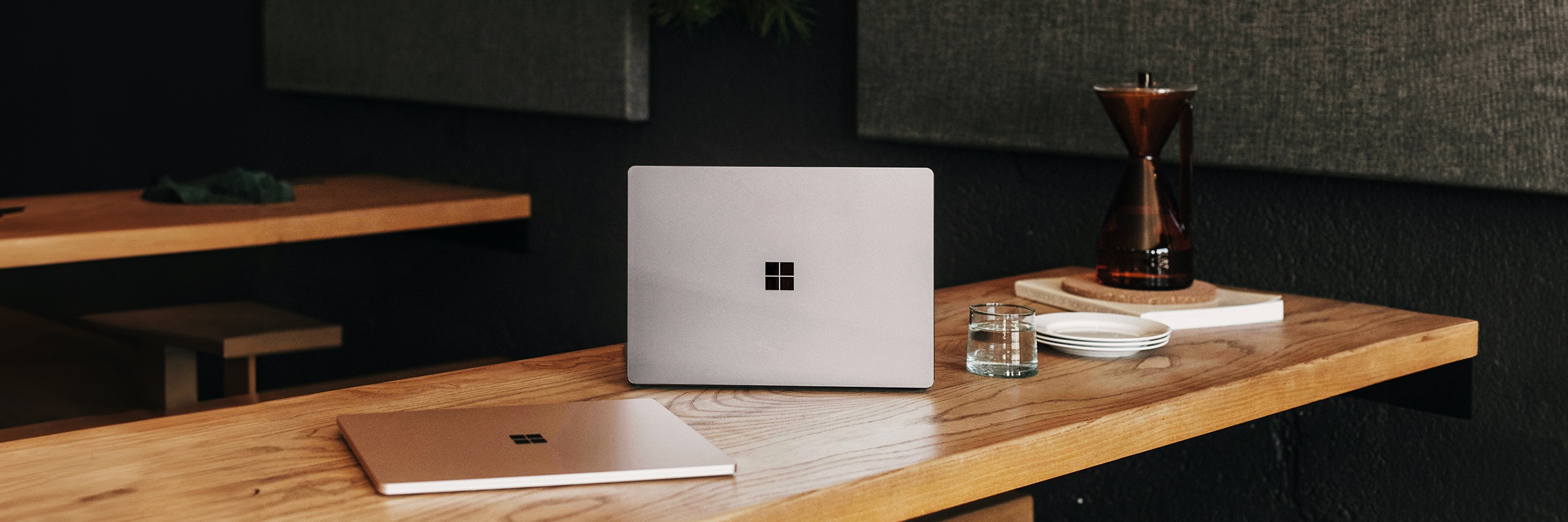 Ein Microsoft Laptop steht auf einem Tisch, daneben liegt ein zweites.